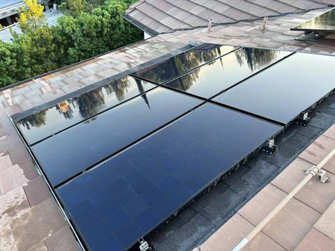 Freshly cleaned black panels with a mirror finish reflecting nearby trees